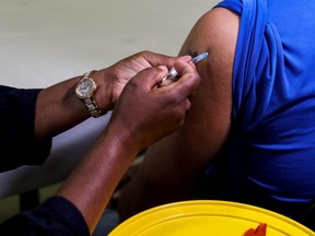A healthcare worker administers the Pfizer COVID-19 vaccine to a man, amidst the spread of the SARS-CoV-2 variant Omicron, in Johannesburg, South Africa, Dec. 9, 2021.