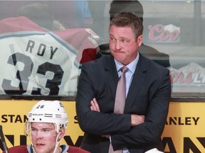 Colorado Avalanche head coach Patrick Roy looks on as a fan holds an old Patrick Roy jersey during game against the Montreal Canadiens at the Bell Centre in Montreal on March 18, 2014.