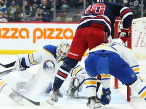 Dec 14, 2021; Winnipeg, Manitoba, CAN; Buffalo Sabres goalie Ukko Pekka Luukkonen (1) makes a save on a shot by Winnipeg Jets forward Pierre-Luc Dubois (80) during the second period at Canada Life Centre. Mandatory Credit: Terrence Lee-USA TODAY Sports