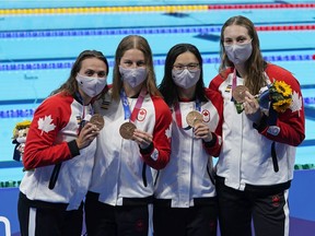 Canada's Kylie Masse, left to right, Sydney Pickrem, Maggie Mac Neil and Penny Oleksiak celebrate a bronze medal in the women's 4 x 100m medley relay final during the Tokyo Summer Olympic Games, in Tokyo, Sunday, August 1, 2021.