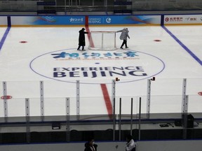 Staff members move a net as they maintain the rink, at an ice hockey competition venue for the 2022 Olympic Winter Games, inside the National Indoor Stadium, in Beijing, China April 1, 2021.