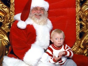 Boy on mall Santa's lap, signing 'help'