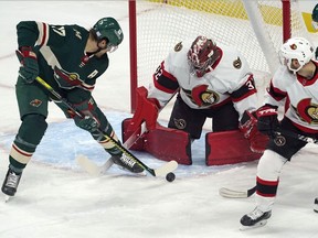 Ottawa Senators goalie Filip Gustavsson (32) makes a stop as Minnesota Wild's Marcus Foligno (17) works on a rebound moments before scoring a goal during the first period of an NHL hockey game Tuesday, Nov. 2, 2021, in St. Paul, Minn.