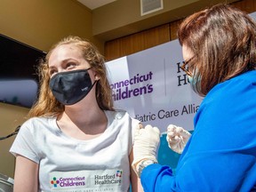 Ruthie Riccoban, age 14, is inoculated by Nurse Karen Pagliaro at Hartford Healthcares mass vaccination center at the Connecticut Convention Center in Hartford, Connecticut on May 13, 2021.