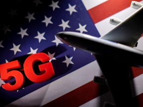 5G words and an airplane toy are placed on a printed U.S. flag in this illustration taken Jan. 18, 2022.