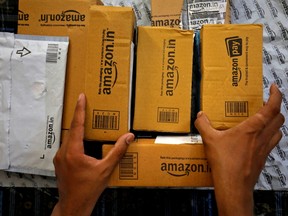 A worker sorts delivery packages in a van outside an Amazon facility in Ahmedabad, India, March 17, 2021.