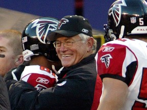 Falcons coach Dan Reeves (C) gets a hug from wide receiver Peerless Price (L) at the end of the Falcons 27-7 win over the New York Giants in their game November 9, 2003. Reeves won his 200th career NFL game.