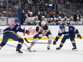 Edmonton Oilers center Leon Draisaitl (29) skates with the puck as New York Islanders defenseman Scott Mayfield (24) and left wing Matt Martin (17) defend during the first period at UBS Arena on Jan . 1, 2022.