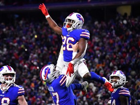 Bills running back Devin Singletary (top) celebrates with quarterback Josh Allen after scoring a touchdown against the Patriots on Saturday night. The Bills won 47-17.