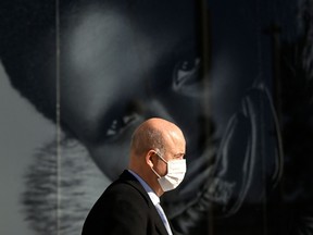 A man wearing a face mask walks in a street in Madrid on Jan. 27, 2022.