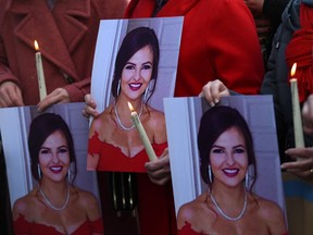 People hold pictures of 23-year-old Ashling Murphy, who was murdered in Tullamore while out jogging, during a memorial outside Government buildings in Dublin, Ireland January 14, 2022.