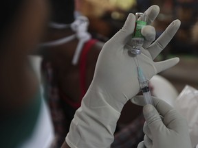 A health worker prepares to administer the Covishield vaccine for COVID-19 at a temple premise in Hyderabad, India, Wednesday, Jan. 12, 2022.