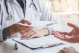 A doctor gives a medical form to a patient.