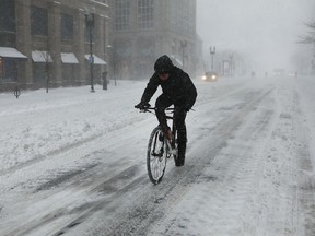 A man rides his bicycle through the empty and snow covered streets of Boston during a massive winter storm on January 4, 2018 in Boston, United States. (Photo by Spencer Platt/Getty Images)