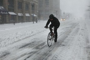 A man rides his bicycle through the empty and snow covered streets of Boston during a massive winter storm on January 4, 2018 in Boston, United States. (Photo by Spencer Platt/Getty Images)