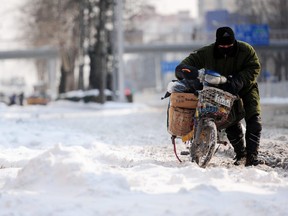Auf diesem Aktenfoto geht ein Postangestellter am 4. Januar 2010 nach starkem Schneefall in Peking eine schneebedeckte Straße entlang.