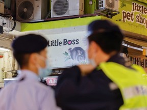 Polizeibeamte stehen vor einer vorübergehend geschlossenen Tierhandlung Wache, nachdem die Regierung angekündigt hatte, rund 2.000 Hamster in der Stadt einzuschläfern, nachdem sie am 18. Januar 2022 in Hongkong zum ersten Mal Beweise für eine mögliche Übertragung der Coronavirus-Krankheit von Tier zu Mensch gefunden hatte.