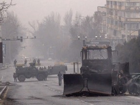 Soldaten und ihre Militärfahrzeuge blockieren am 7. Januar 2022 eine Straße im Zentrum von Almaty, Kasachstan, nachdem nach Protesten gegen die Erhöhung der Kraftstoffpreise Gewalt ausgebrochen war.