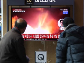 Menschen sehen am Bahnhof von Seoul einen Fernseher, der ein Dateibild eines nordkoreanischen Raketenstarts am 5. Januar 2022 in Seoul, Südkorea, zeigt