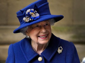 In this file photo taken on Oct. 12, 2021 Queen Elizabeth II smiles as she leaves after attending a Service of Thanksgiving to mark the Centenary of the Royal British Legion at Westminster Abbey in London.