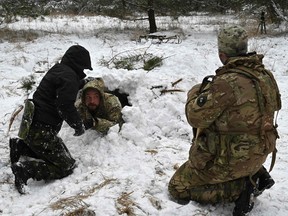 Ukrainische Zivilisten lernen am 30. Januar 2022 in einem Wald am Stadtrand von Kiew im Rahmen eines Crashkurses in Überlebenstechniken, wie man einen Unterschlupf aus dem tiefen Schnee baut.