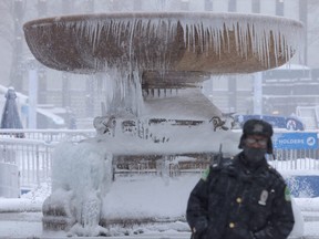Eine Person steht während eines Nor'easter-Sturms in Manhattan, New York City, am 29. Januar 2022 vor einem gefrorenen Brunnen im Bryant Park.