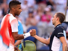 Britain's Daniel Evans (R) greets Canada's Felix Auger-Aliassime after their men's singles match on day six of the Australian Open tennis tournament in Melbourne on January 22, 2022.