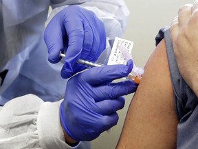 A subject receives a shot in the first-stage safety study clinical trial of a potential vaccine by Moderna for COVID-19 at the Kaiser Permanente Washington Health Research Institute in Seattle, March 16, 2020.