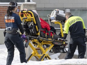 Ambulance workers transport a patient to the emergency room as hospitalizations continue to rise due to the COVID-19 pandemic Wednesday, January 5, 2022 in Montreal.