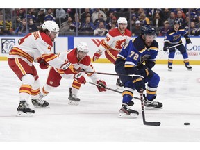 Calgary Flames defenceman Rasmus Andersson (4) and winger Johnny Gaudreau (13) defend against St. Louis Blues defenceman Justin Faulk at Enterprise Center in St. Louis on Thursday, Jan. 27, 2022.