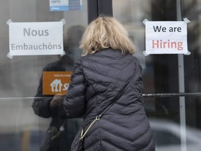 A customer enters a restaurant with help wanted signs in Laval, Que., Nov. 17, 2021 as employers deal with the labour shortage.