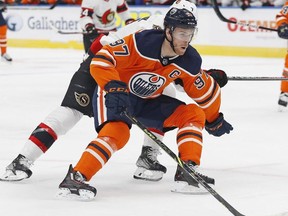 Edmonton Oilers forward Connor McDavid carries the puck around Ottawa Senators forward Brady Tkachuk during the first period at Rogers Place.