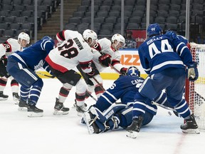 Senators right-winger Connor Brown (28) watches as teammate Alex Formenton (top) tries, but fails to slide the puck past Toronto Maple Leafs goaltender Jack Campbell (36) during the second period of Saturday's game.