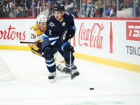 Winnipeg Jets defenceman Dylan DeMelo (2) skates away from Nashville Predators forward Philip Tomasino (26) during the first period at Canada Life Centre in Winnipeg on Oct. 23, 2021.