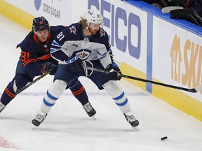 Edmonton Oilers forward Gaetan Haas (91) and Winnipeg Jets forward Kyle Connor (81) chase a loose puck at Rogers Place. Perry Nelson-USA TODAY Sports