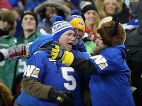 Winnipeg Blue Bomber fans celebrate a win over the Saskatchewan Roughriders in the CFL West Final in Winnipeg on Sunday, Dec. 5, 2021.