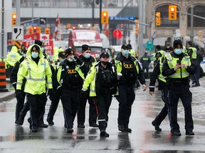Polizeibeamte patrouillieren am 17. Februar 2022 in Ottawa auf der Wellington Street, während Trucker und Unterstützer weiterhin gegen Impfmandate protestieren.