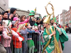 Saint Patrick as portrayed by Irish actor Johnny Murphy clowns around with children watching the St. Patrick's Day parade in Dublin, Ireland, Friday, March 17, 2017.