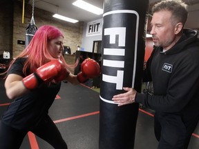 Sophia Logie, 16, works the heavy bag with Jason Battiste, owner of the boxing gym FIIT (Fight Inspired Interval Training) on Gerrard St. East at Jones Ave. for a lunchtime workout as businesses have yet again reopened on Monday January 31, 2022. Jack Boland/Toronto Sun/Postmedia Network