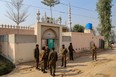 Police gather near the site where a man was killed after allegedly an angry mob stoned him to death at Khanewal district on February 13, 2022. (Photo by SHAHID SAEED MIRZA/AFP via Getty Images)