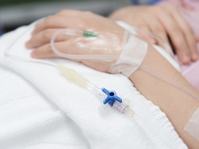 An IV needle on a patient in a hospital.
