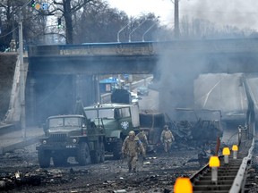 Ukrainian service members are seen at the site of a fighting with Russian raiding group in the Ukrainian capital of Kyiv in the morning of Feb. 26, 2022, according to Ukrainian service personnel at the scene.