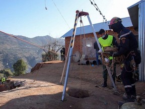 Retter stehen am Samstag, 5. Februar 2022, in der nördlichen Bergstadt Chefchaouen, Marokko, in der Nähe eines Brunnenlochs, in das ein fünfjähriger Junge gefallen ist.