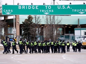 Canadian police deploy on February 12, 2022, to move protesters blocking access to the Ambassador Bridge in Windsor.