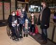 Retired Canadian Forces Lt.-Col. Tony White greets Ahmad Seyar Sadiqi (L), aka Radar, as he arrives in Ottawa with his wife Tamana, their two-year-old daughter Ossna, and sons Mohammad, 4, and Sajad, 10, on Thursday, Feb. 11, 2022.
