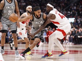 Patty Mills of the Brooklyn Nets dribbles past Pascal Siakam of the Toronto Raptors during the first half of their NBA game at Scotiabank Arena on March 1, 2022 in Toronto, Canada.