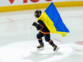 Scotiabank Skater Jacob Paquet skates with the flag of Ukraine before the NHL game between the Edmonton Oilers and the Montreal Canadiens at Rogers Place in Edmonton, on Saturday, March 5, 2022.