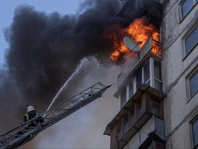 Feuerwehrleute arbeiten am 15. März 2022 in Kiew, um ein Feuer in einem Wohnhaus zu löschen, nachdem es von Beschuss getroffen wurde, während die russische Invasion in der Ukraine weitergeht.