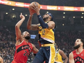 Pacers forward Oshae Brissett (12) drives to the basket against Toronto Raptors center Khem Birch on Saturday night at Scotiabank Arena.