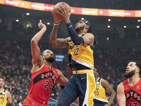 Pacers forward Oshae Brissett (12) drives to the basket against Toronto Raptors centre Khem Birch (24) during the first quarter at Scotiabank Arena on Saturday night.